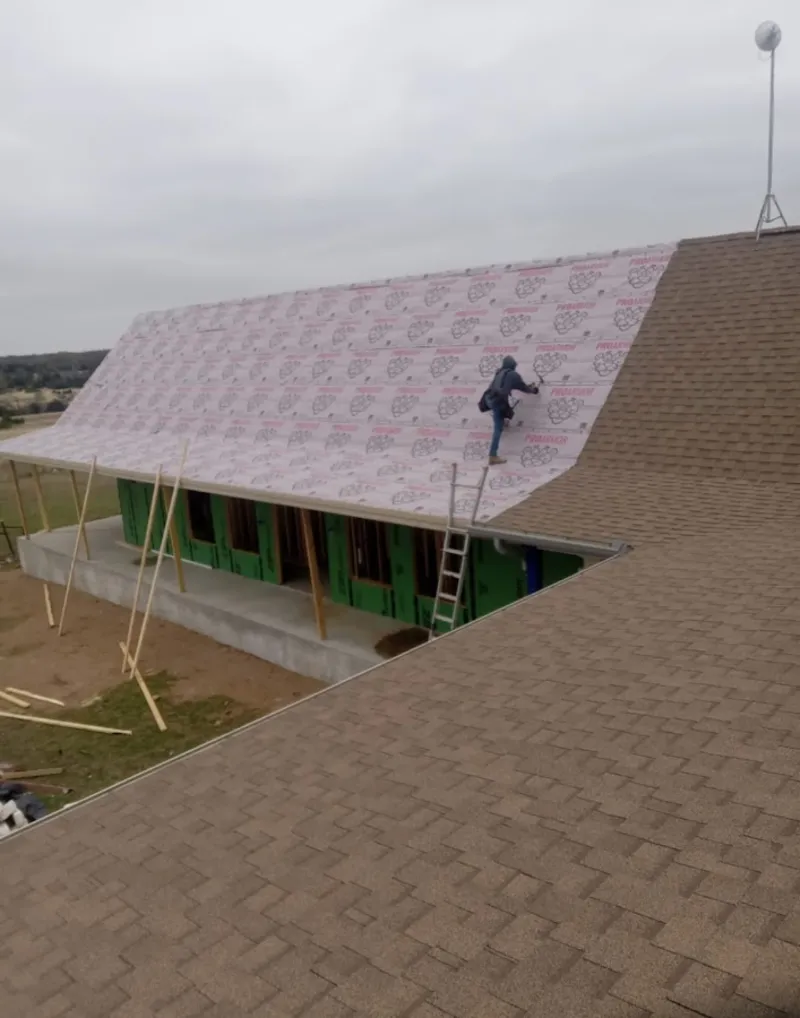Worker preparing underlayment for a metal roof installation in Horizon City